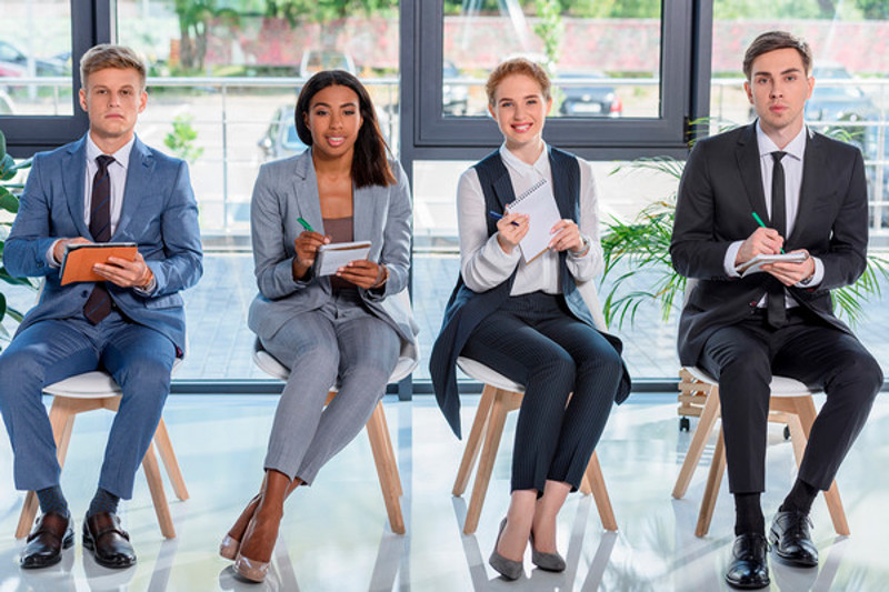 Students in suits sit in a row looking attentive